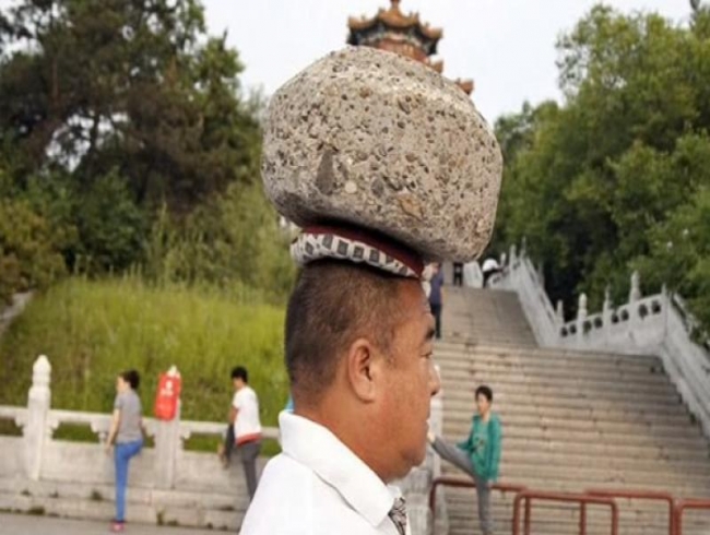 Chinese man walks around with 40kg rock on his head to lose weight